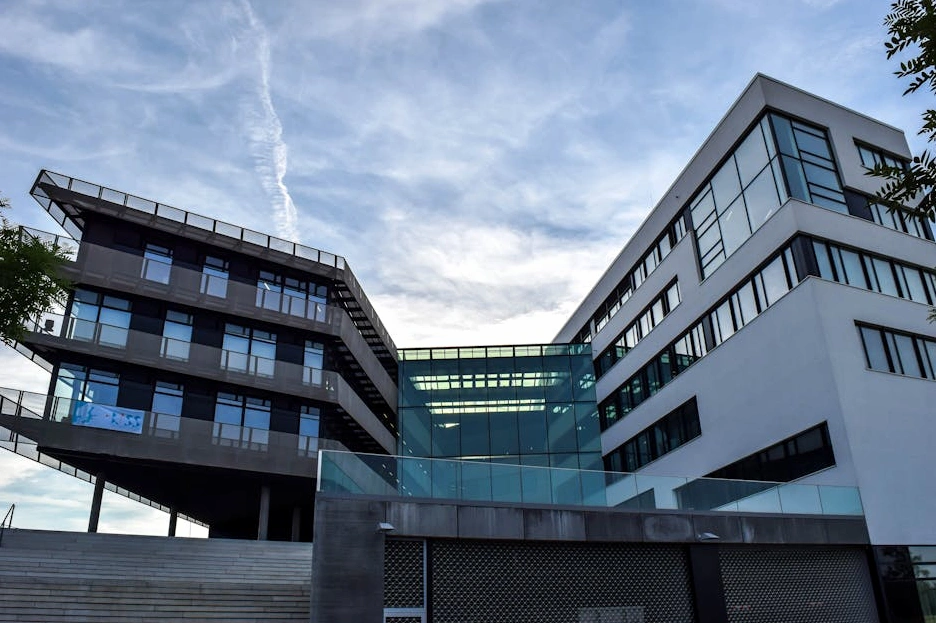 The modern, geometric facade of a corporate headquarters at dusk.
